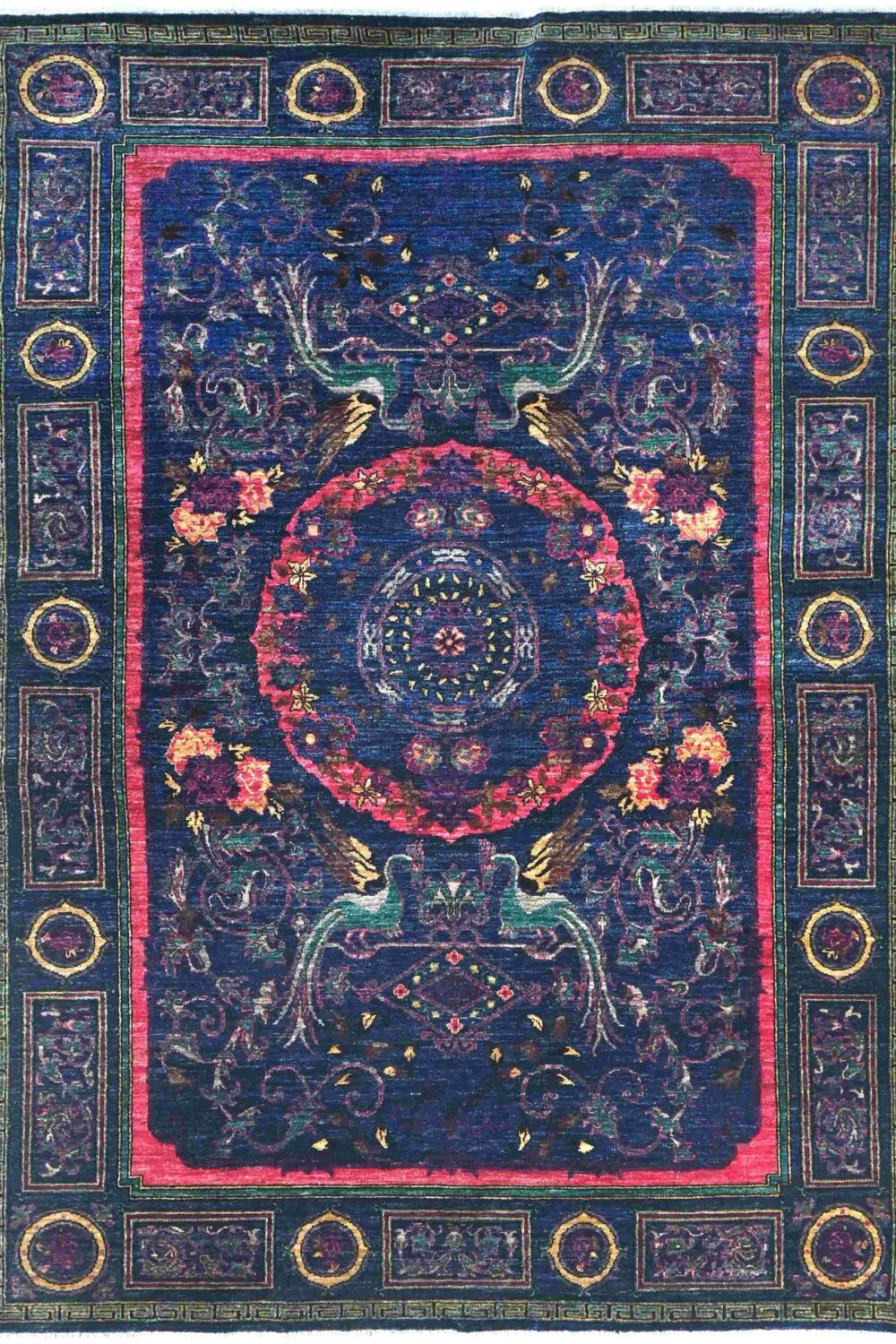 Handmade oriental rug, size 9 x 6 rug featuring a rich navy-blue background with vibrant pink, green, and gold accents, intricate floral patterns, and symbolic bird motifs, ideal for adding a bold touch to any space.