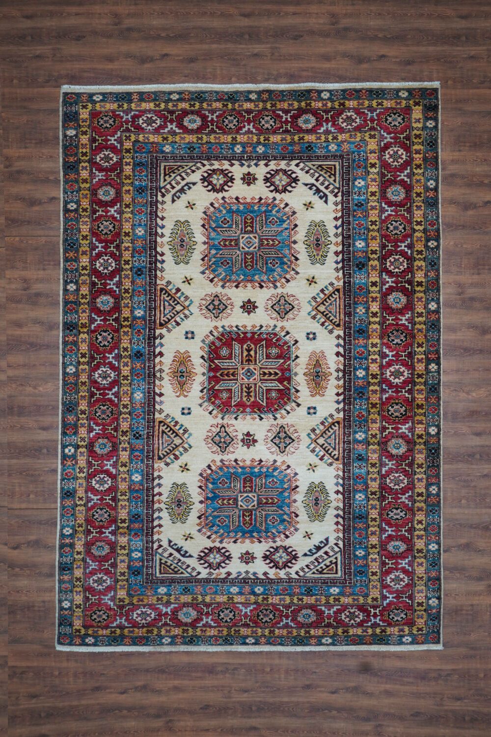 Super kazzak 6 x 8 beige rug with vibrant geometric and floral patterns, bordered by intricate multicolored designs, perfect for living spaces.