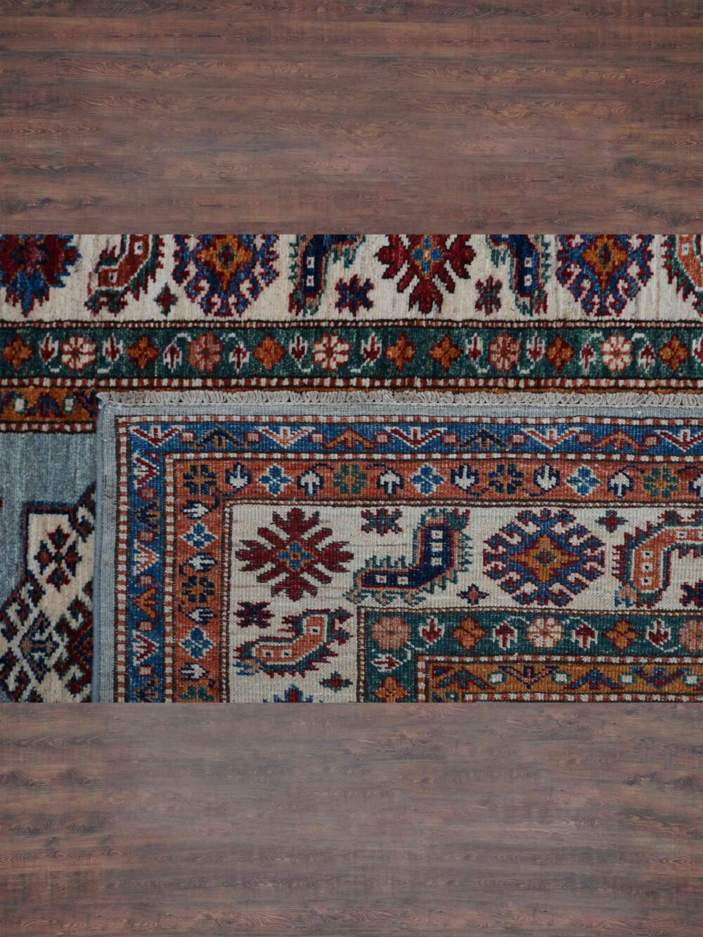 Supper kazzak 6 x 7 light blue rug adorned with red and blue geometric medallions, surrounded by intricate multicolored floral borders and patterns.