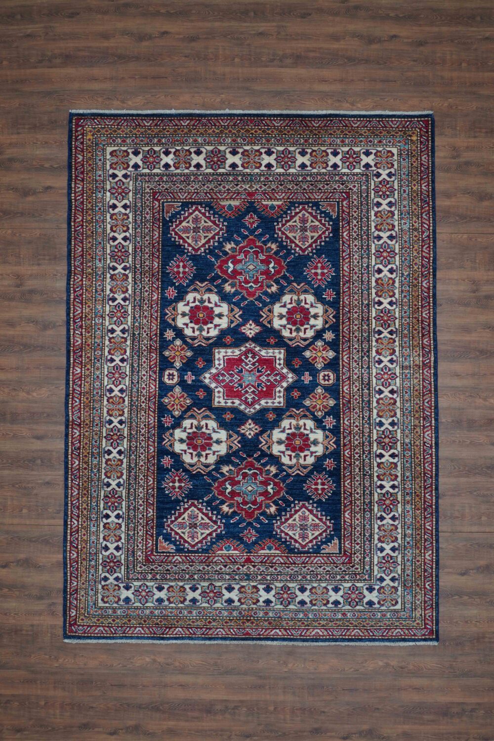 Super kazzak 5 x 7 traditional blue rug with red and white floral medallions, intricate geometric patterns, and detailed borders. washable rug