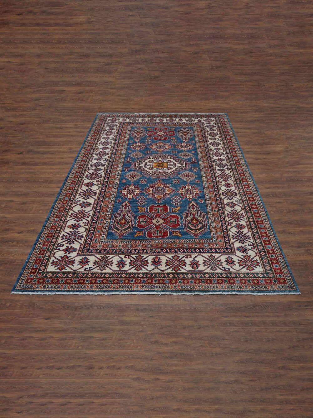 Super Kazzak 6 x 8 Traditional blue rug with geometric medallions, floral designs, intricate white borders, and vibrant multicolor accents.