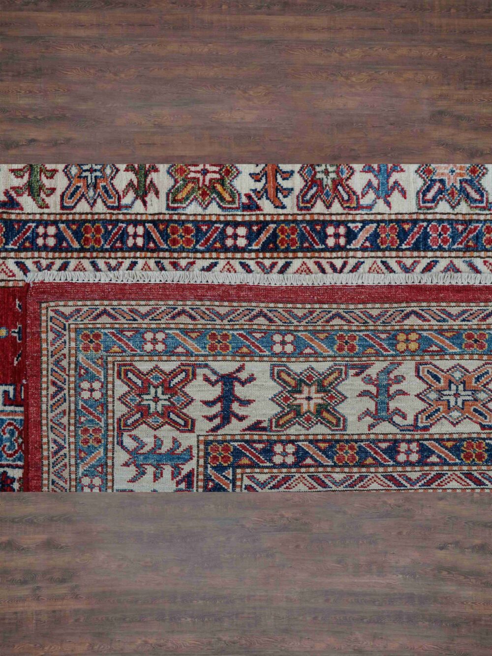 Super kazzak traditional 5x8 rug featuring a rich red background with detailed motifs in blue and white, framed by ornate floral and geometric borders, designed for use in a living room rug.