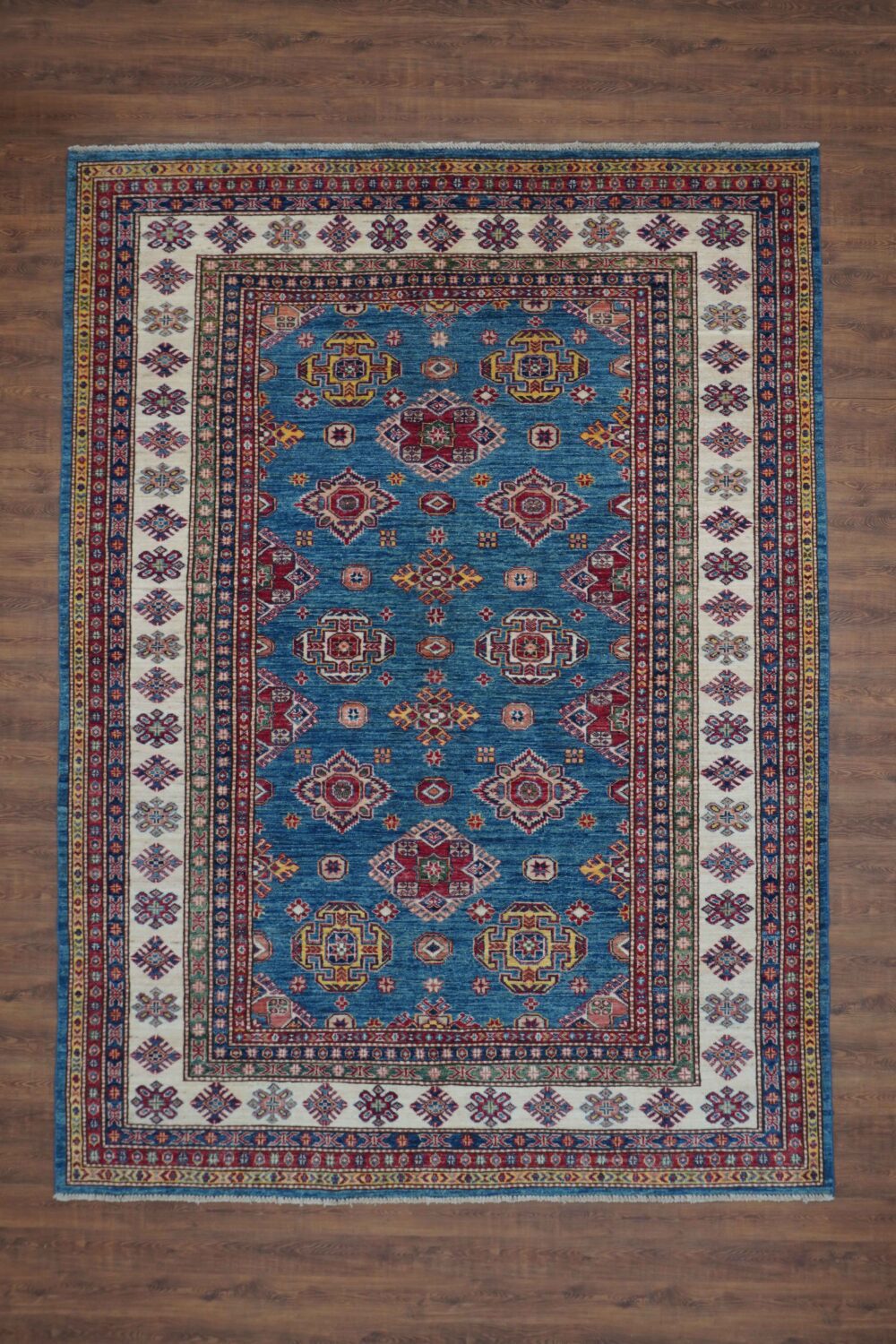 Super Kazzak 6 x 8 Traditional blue rug with intricate geometric and floral patterns, vibrant colors, and detailed borders. A perfect centerpiece for any decor.