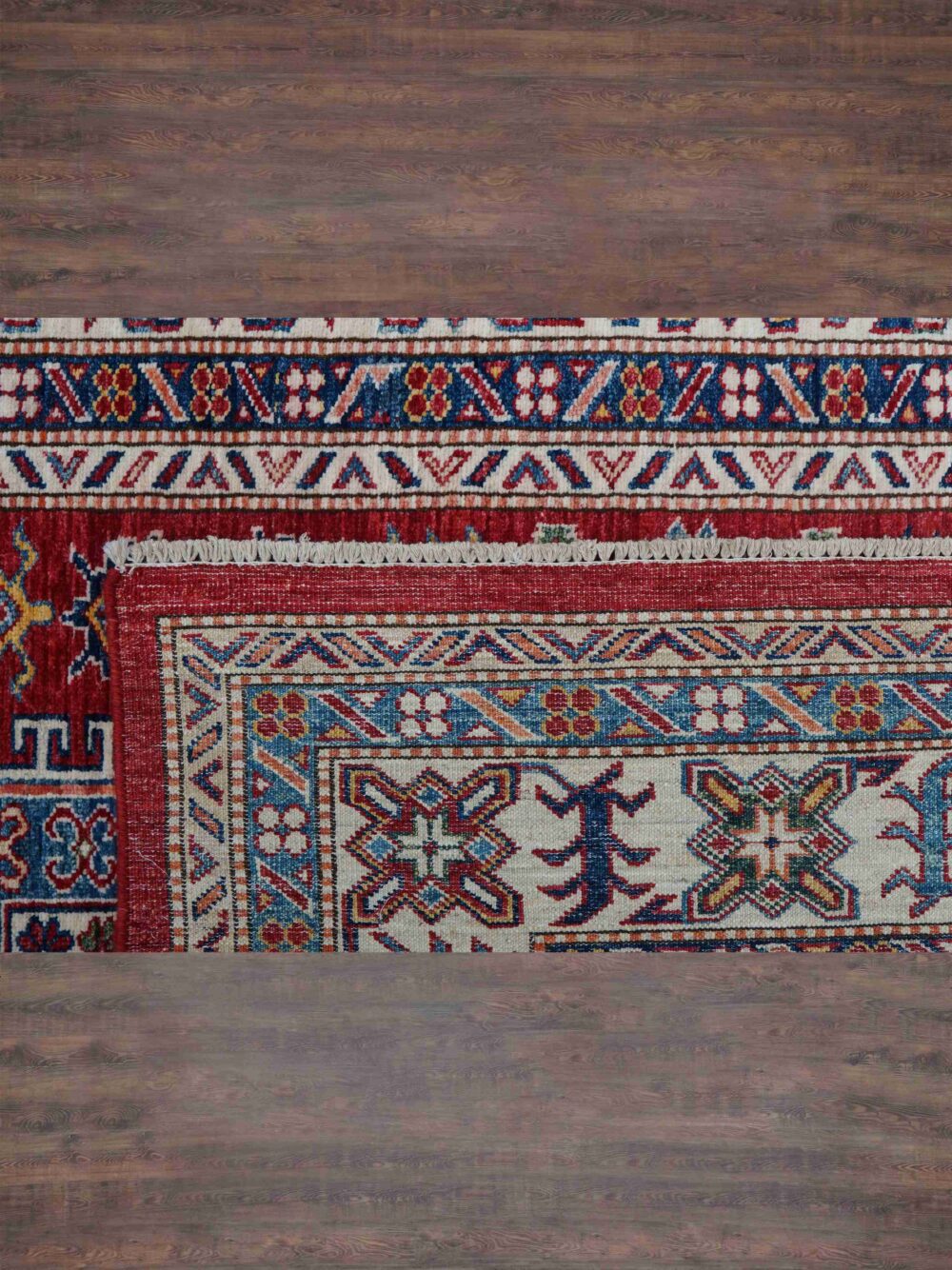 Super kazzak traditional 6 x 8 rug featuring a rich red background with detailed motifs in blue and white, framed by ornate floral and geometric borders, designed for use in a living room rug.